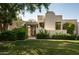 Front view of a stucco home with green lawn, gate, and mature trees at 3186 E Stella Ln, Phoenix, AZ 85016