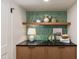 Functional laundry room with stylish green backsplash, floating shelves, and ample countertop space at 3186 E Stella Ln, Phoenix, AZ 85016