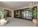 Covered patio featuring sliding glass doors, tiled flooring, and potted plants at 3186 E Stella Ln, Phoenix, AZ 85016