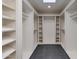 Spacious walk-in closet with custom shelving, a skylight, and dark tile flooring at 3186 E Stella Ln, Phoenix, AZ 85016