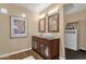 Bathroom showcasing double sinks, wood look flooring and framed sunflower artwork at 3221 N 37Th St # 10, Phoenix, AZ 85018