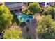 A bird's-eye view of a backyard with a freeform pool, lush landscaping, and a covered patio at 32311 N Cat Hills Ave, San Tan Valley, AZ 85144