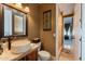 Bathroom featuring a vessel sink, decorative mirror, and open doorway to a beautifully designed shower at 32311 N Cat Hills Ave, San Tan Valley, AZ 85144