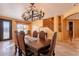 Warm dining room with rustic wood table, decorative chandelier, and staircase at 32311 N Cat Hills Ave, San Tan Valley, AZ 85144
