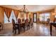 Elegant dining room features ornate chandelier, stone floors, and draped windows at 32311 N Cat Hills Ave, San Tan Valley, AZ 85144