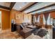 Cozy living room features exposed beam ceiling, leather sectional, and custom art at 32311 N Cat Hills Ave, San Tan Valley, AZ 85144