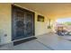 Covered patio area with intricate double door, TV, and outdoor seating, perfect for entertaining at 32311 N Cat Hills Ave, San Tan Valley, AZ 85144