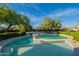 Inviting kidney-shaped pool with a sunbathing area, enveloped by mature trees and manicured hedges at 32311 N Cat Hills Ave, San Tan Valley, AZ 85144