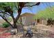 Rear of house showcasing large trees, landscaped backyard, and exterior patio seating area at 32516 N 68Th Pl, Scottsdale, AZ 85266