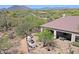 View of the outdoor patio with seating, a built in fireplace and mountain views at 32516 N 68Th Pl, Scottsdale, AZ 85266