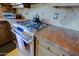 Close-up of a stainless steel gas range with granite countertops and decorative backsplash in the kitchen at 32516 N 68Th Pl, Scottsdale, AZ 85266
