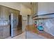 Kitchen view with stainless steel refrigerator, granite countertops, tiled backsplash, and wooden cabinets at 32516 N 68Th Pl, Scottsdale, AZ 85266