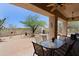 Spacious covered patio with ceiling fans, BBQ area, an outdoor fireplace, and a dining space at 32516 N 68Th Pl, Scottsdale, AZ 85266