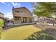 Two-story home backyard with an outdoor kitchen, pool, putting green, and patio seating at 3859 N El Sereno St, Mesa, AZ 85207