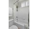 Bright bathroom featuring a white tiled tub/shower, toilet, white towel rack and window at 3859 N El Sereno St, Mesa, AZ 85207