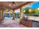 Covered patio with outdoor kitchen featuring a stainless steel grill and beverage fridge overlooking the pool at 3859 N El Sereno St, Mesa, AZ 85207