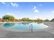 Large community pool with a clear blue water, lounge chairs, and meticulously maintained landscaping at 3859 N El Sereno St, Mesa, AZ 85207