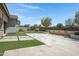Well-maintained backyard featuring stone patio, artificial turf, desert landscaping, and water feature at 41465 W Sussex Dr, Maricopa, AZ 85138