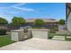 Backyard includes built-in BBQ and entertaining space with a stone patio and artificial turf at 41465 W Sussex Dr, Maricopa, AZ 85138