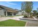 Expansive backyard featuring a stone patio, artificial turf, and attractive desert landscaping at 41465 W Sussex Dr, Maricopa, AZ 85138