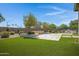 Wide open backyard with stone pavers, artificial turf, desert landscaping, and outdoor built-in BBQ at 41465 W Sussex Dr, Maricopa, AZ 85138
