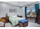 Cozy bedroom with a green bedspread, wood furniture, and bright natural light at 41465 W Sussex Dr, Maricopa, AZ 85138