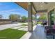 Relaxing covered patio boasts stone pavers, artificial turf, with view of water feature at 41465 W Sussex Dr, Maricopa, AZ 85138