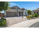 Attractive home featuring a brick-paved driveway and lush landscaping, with a convenient two-car garage at 41465 W Sussex Dr, Maricopa, AZ 85138