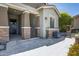 Inviting front porch with stylish tiled flooring, brick pillars and a cozy seating area at 41465 W Sussex Dr, Maricopa, AZ 85138