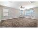 Inviting bedroom with plush carpet, a ceiling fan, and large windows, providing natural light at 4277 N 180Th Ln, Goodyear, AZ 85395