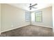 Neutral bedroom featuring two windows, a ceiling fan, and carpeted floors at 4277 N 180Th Ln, Goodyear, AZ 85395