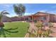 Well-maintained backyard features lush artificial turf and desert landscaping at 43935 W Sagebrush Trl, Maricopa, AZ 85138