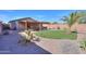 Lush backyard features desert landscaping, privacy wall, and covered patio at 43935 W Sagebrush Trl, Maricopa, AZ 85138