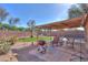 Landscaped backyard offers a charming pergola and BBQ, ideal for outdoor living at 43935 W Sagebrush Trl, Maricopa, AZ 85138