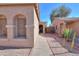 Home exterior showing desert landscaping, plants, and pathway leading to front door at 43935 W Sagebrush Trl, Maricopa, AZ 85138