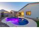 Private backyard oasis with a sparkling pool, patio, and mountain views at twilight at 4593 W Bush Bean Way, San Tan Valley, AZ 85144