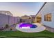 Backyard oasis featuring a private pool with LED lighting and desert landscaping at twilight at 4593 W Bush Bean Way, San Tan Valley, AZ 85144