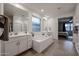 Bright and spacious bathroom featuring a large soaking tub and dual vanities with great natural light at 4593 W Bush Bean Way, San Tan Valley, AZ 85144