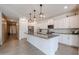 Bright kitchen features white cabinets, granite countertops, stainless appliances, and stylish pendant lighting at 4593 W Bush Bean Way, San Tan Valley, AZ 85144