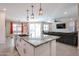 Open-concept kitchen showcases a large island with granite counters, stainless sink, and adjacent living area at 4593 W Bush Bean Way, San Tan Valley, AZ 85144