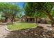 Expansive backyard featuring a well-manicured lawn, a covered patio, and desert landscaping providing a private retreat at 5232 N 186Th Dr, Litchfield Park, AZ 85340