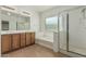 Bright bathroom featuring a double sink vanity, soaking tub, and glass-enclosed shower at 5232 N 186Th Dr, Litchfield Park, AZ 85340