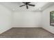 Spacious bedroom featuring a ceiling fan, neutral carpeting, and a window providing natural light at 5232 N 186Th Dr, Litchfield Park, AZ 85340