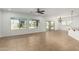 Spacious living room featuring neutral tile flooring, large windows, and a ceiling fan at 5232 N 186Th Dr, Litchfield Park, AZ 85340