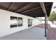 A covered back patio shows windows, a sliding glass door and desert landscaping at 6254 E Winchcomb Dr, Scottsdale, AZ 85254
