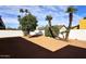 Expansive backyard area with a privacy wall, gravel landscaping and mature trees at 6254 E Winchcomb Dr, Scottsdale, AZ 85254