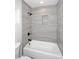 Bright bathroom with tub and shower combo featuring modern gray tile and black fixtures at 6254 E Winchcomb Dr, Scottsdale, AZ 85254