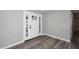 Bright entryway featuring modern front door, light gray walls, and beautiful wood-look flooring at 6254 E Winchcomb Dr, Scottsdale, AZ 85254