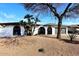 Charming home featuring an arched entryway, desert landscaping, and a two-car garage at 6254 E Winchcomb Dr, Scottsdale, AZ 85254