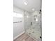 Newly remodeled walk-in shower with frameless glass door and neutral marble-style tile at 6254 E Winchcomb Dr, Scottsdale, AZ 85254